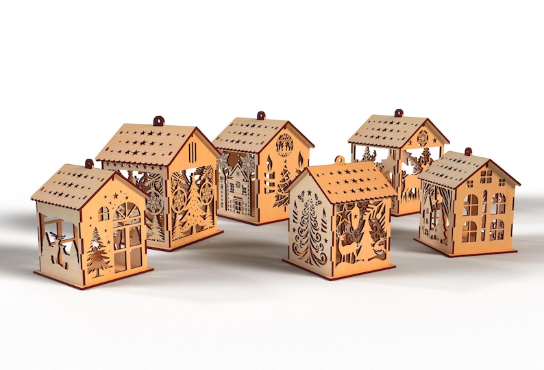 Peut inclure: Plusieurs photophores en forme de maison en bois d&eacute;coup&eacute; au laser. Chaque maison pr&eacute;sente des motifs d&eacute;coup&eacute;s de stars, d'arbres et d'&eacute;l&eacute;ments festifs. Les maisons sont en bois brun clair et sont con&ccedil;ues pour contenir des bougies.
