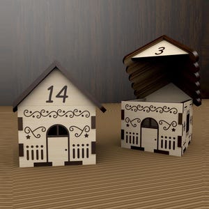 May include: Two decorative wooden house-shaped boxes. One has the number 14 on the roof, the other has the number 3. Both have decorative cut-out designs, including a door, windows, and star accents. The houses are on a wooden surface.