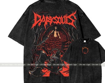 May include: Two black t-shirts. The larger shirt features the red text "DARK SOULS" above a graphic of a woman in a red dress. The smaller shirt has an orange circle design. Both shirts have short sleeves.