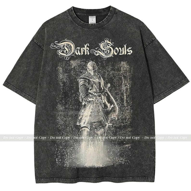 Op de afbeelding: Donkergrijs T-shirt met een verweerde afbeelding van een ridder met zwaard en schild, met de tekst "Dark Souls". Het shirt heeft een vintage, versleten uitstraling.