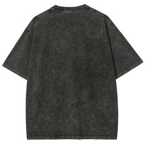 Op de afbeelding: Een oversized, antracietgrijs T-shirt met een vervaagde, getextureerde uitstraling. Het shirt met korte mouwen heeft een ronde hals en een relaxte pasvorm. De stof heeft een vintage, versleten look.