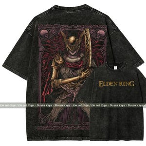May include: Black graphic t-shirt featuring a detailed illustration of a character with a sword, set within a decorative frame. The shirt has a vintage wash effect. The text "ELDEN RING" is printed on the front of a smaller shirt.