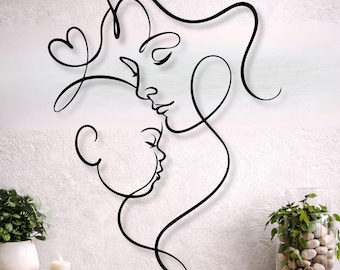 Puede incluir: Arte mural de metal negro que representa a una madre y un niño en un diseño de línea continua. La obra de arte presenta una forma de corazón y líneas fluidas, creando una estética minimalista y moderna. Montado en una pared blanca texturizada.