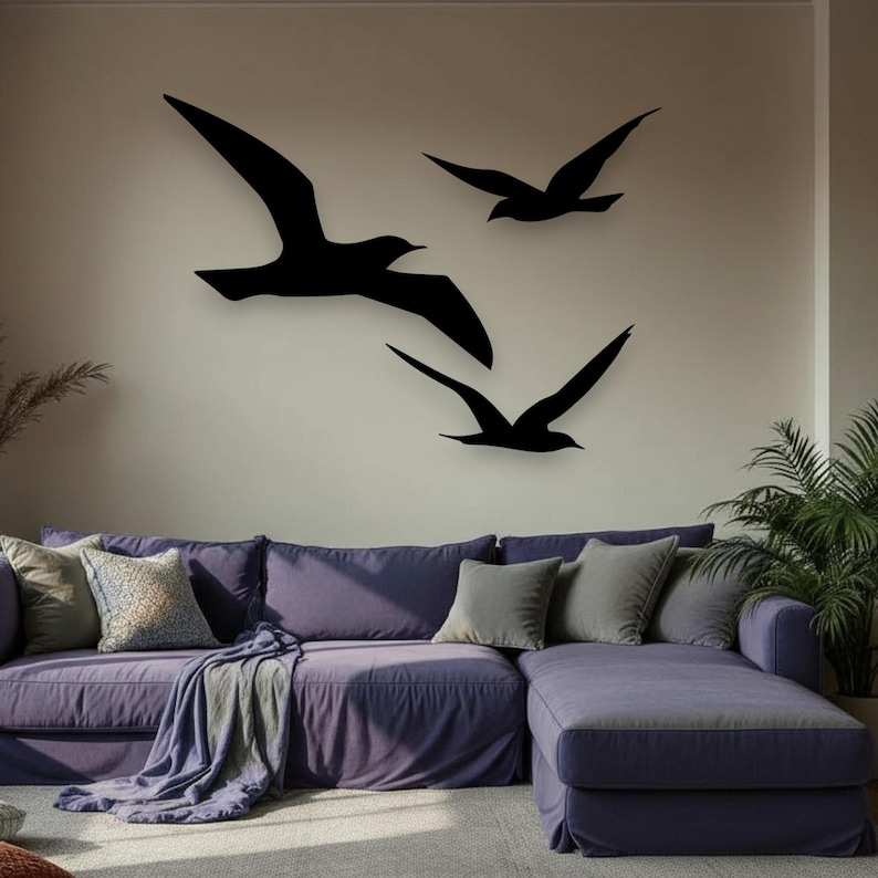 Puede incluir: Tres siluetas de aves negras montadas en una pared. El ave m&aacute;s grande est&aacute; situada a la izquierda con las alas extendidas, mientras que dos aves m&aacute;s peque&ntilde;as est&aacute;n dispuestas a la derecha, una sobre otra, todas en movimiento de vuelo.