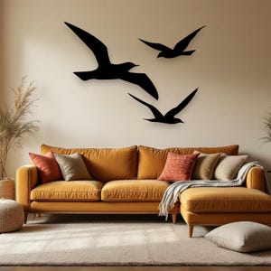 Puede incluir: Tres siluetas de aves negras montadas en una pared. El ave m&aacute;s grande est&aacute; situada a la izquierda con las alas extendidas, mientras que dos aves m&aacute;s peque&ntilde;as est&aacute;n dispuestas a la derecha, una sobre otra, en formaci&oacute;n de vuelo.