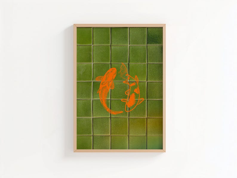May include: Framed art print featuring two orange koi fish swimming in a circle. The background is a grid of green square tiles. The frame is a light wood color. The artwork is displayed on a white wall.
