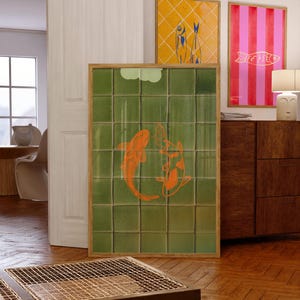 May include: A framed artwork featuring two orange koi fish on a green tiled background. Two additional framed artworks are visible, one with a yellow diamond pattern and blue fish, and another with pink and red stripes and a gold fish.
