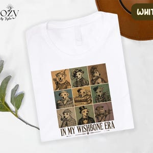 A white t-shirt with a graphic design featuring a collage of nine animal portraits arranged in a 3x3 grid, along with the text "IN MY WISHBONE ERA".