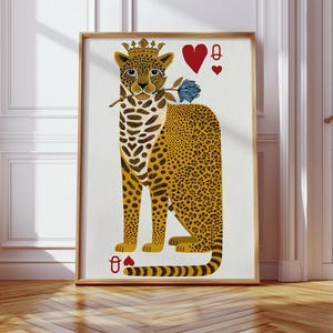 May include: A framed art print featuring a stylized leopard wearing a crown and holding a blue rose. The leopard has yellow and black spots, with playing card symbols of hearts and a queen. The artwork is in a wooden frame.