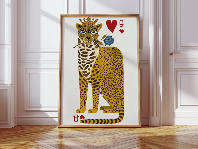 May include: A framed art print featuring a stylized leopard wearing a crown and holding a blue rose. The leopard has yellow and black spots, with playing card symbols of hearts and a queen. The artwork is in a wooden frame.