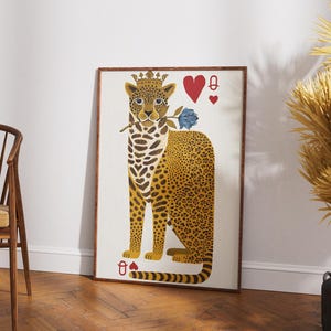 May include: A framed art print featuring a stylized leopard wearing a crown and holding a blue rose. The leopard has a yellow and brown spotted coat. The artwork includes playing card symbols: a red heart and a spade.