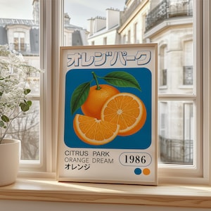 May include: A vintage-style poster with a blue background featuring a sliced orange with green leaves. The poster has the text "Orange Park" in Japanese characters, "Citrus Park Orange Dream" and "1986" in white text.