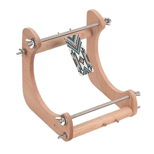 May include: A light-colored wooden bead loom featuring two curved side supports, two horizontal metal rods with threaded ends, and silver wing nuts. A partially woven strip of small beads in a geometric pattern of teal, white, and brown is attached.