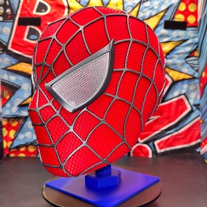 May include: A white ceramic mug with a black handle and the text "But First, Coffee" in a bold, black font. The mug is set against a blurred background, highlighting its simple design.