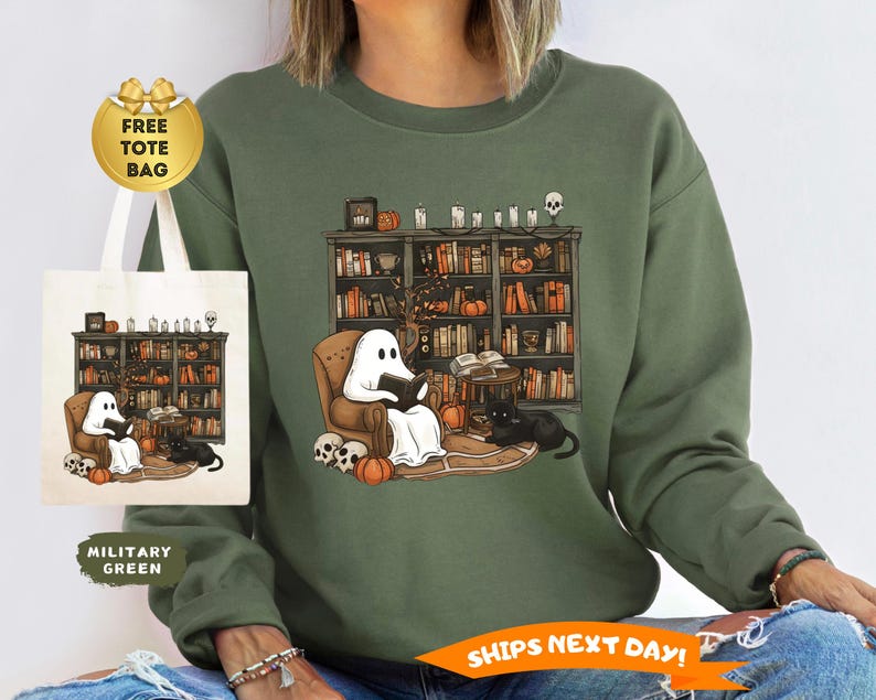 May include: Military green sweatshirt featuring a Halloween-themed graphic. The design shows a ghost reading in a cozy armchair in front of a bookshelf, with a black cat, pumpkins, and skulls. A tote bag with the same design is included.