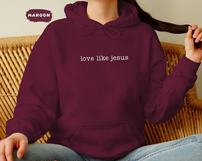 May include: Maroon hoodie with the text "love like jesus" in white. The hoodie has a drawstring hood and a front pocket. The word "MAROON" is in a maroon rectangle in the upper left corner.