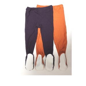 May include: Two pairs of baby leggings with grippy feet. One pair is purple and the other is orange.