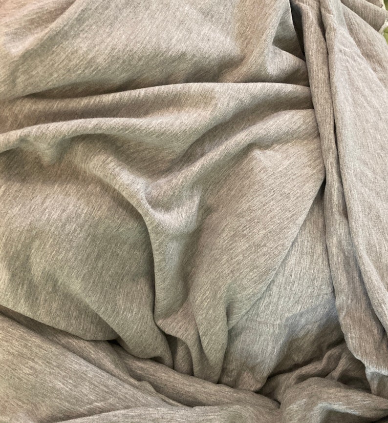 May include: A close-up of a gray, textured fabric with a soft, wrinkled appearance.