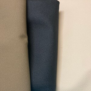 May include: Three fabric swatches, one beige, one black, and one off-white. The fabric has a textured surface.