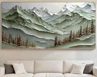 以下が含まれることがあります： セージグリーン、白、グレーの色調で描かれた雪を頂いた山々の質感のあるインパスト風景画の大きな長方形のウォールアートで、山脈の麓には茶色の松の木が密集した森が描かれています。