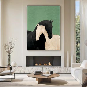 May include: A framed art print featuring two horses. One horse is black, and the other is off-white. The background is a solid green color. The artwork is displayed above a fireplace in a modern living room.