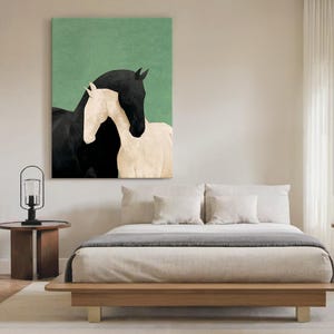 May include: A canvas print featuring two horses. One horse is black, and the other is white. The horses are positioned close together, with the black horse's head above the white horse. The background is a solid green color.