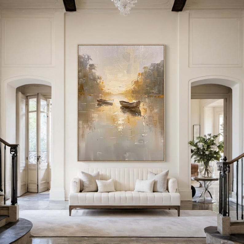 K&ouml;nnte beinhalten: Ein gro&szlig;es rechteckiges Leinwandgem&auml;lde mit zwei kleinen Booten, die auf einem ruhigen Gew&auml;sser schwimmen. Das Kunstwerk verwendet eine Palette aus sanften Gold-, Beige- und Graut&ouml;nen, um eine ruhige Landschaft mit B&auml;umen am Ufer darzustellen.