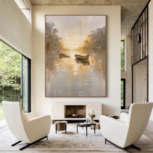 K&ouml;nnte beinhalten: Ein gro&szlig;es rechteckiges &Ouml;lgem&auml;lde mit zwei kleinen Booten auf einem ruhigen Gew&auml;sser. Das Kunstwerk verwendet eine Palette aus sanften Gold-, Beige- und ged&auml;mpften Graut&ouml;nen mit dicken, sichtbaren Pinselstrichen, die B&auml;ume am Ufer darstellen.