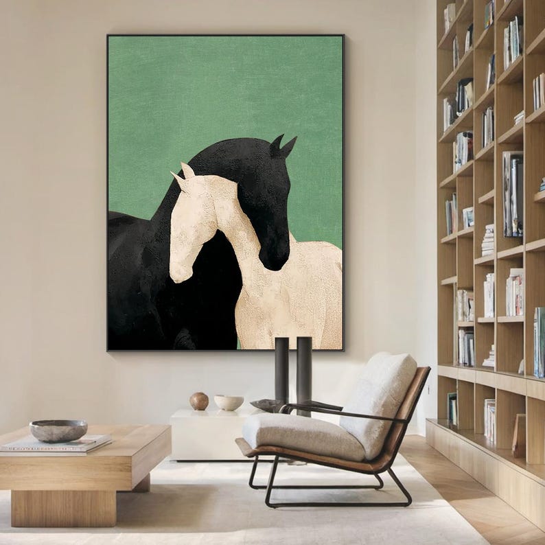 May include: A framed art print featuring two horses. One horse is black, and the other is white, set against a green background. The horses are positioned close together, creating a sense of connection. The artwork is displayed in a modern living space.