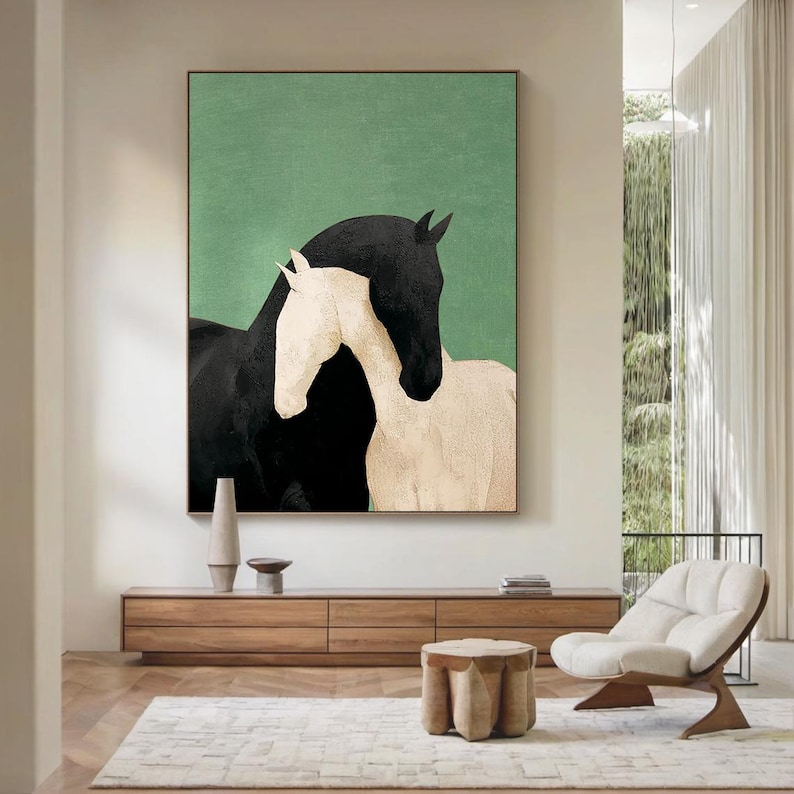May include: Abstract art print featuring two horses. One horse is black, and the other is white, set against a green background. The artwork is framed and displayed in a modern living space.