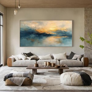 Peut inclure: Une grande peinture de paysage rectangulaire pr&eacute;sentant des coups de pinceau abstraits dans des tons bleu marine profond, sarcelle et jaune dor&eacute; chaud, repr&eacute;sentant une ligne d'horizon avec un effet lumineux, dans un cadre en bois clair.