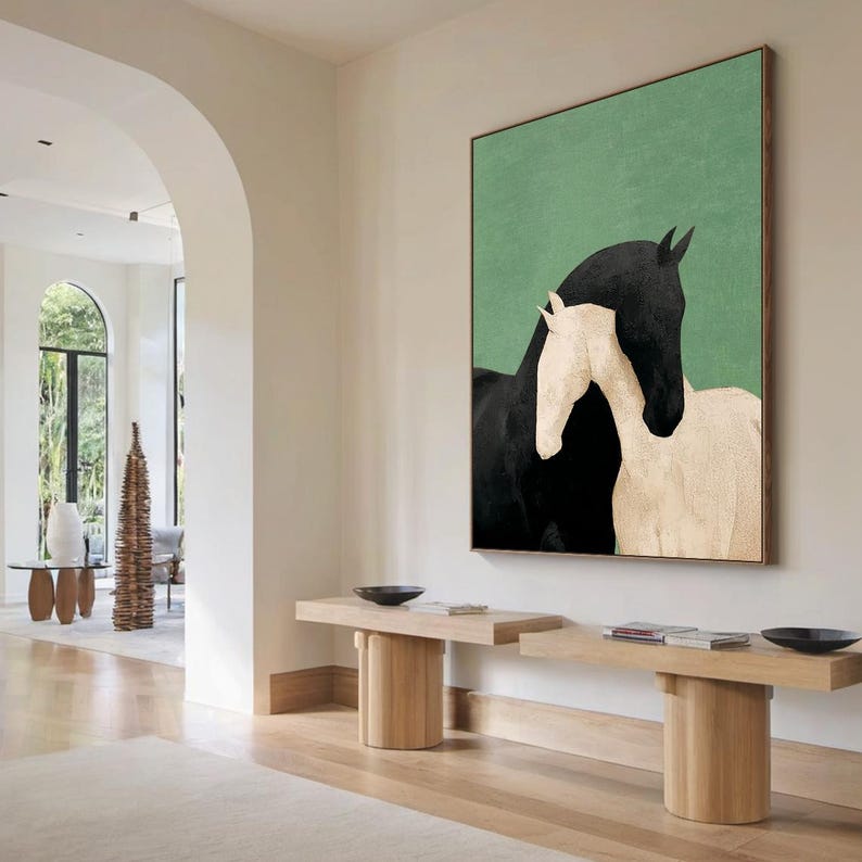 May include: A framed art print featuring two horses. One horse is black, and the other is white, set against a green background. The artwork is displayed in a well-lit hallway with wooden benches.