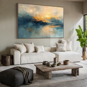 Peut inclure: Une grande peinture de paysage rectangulaire repr&eacute;sentant des nuages abstraits dans des tons de bleu profond, de sarcelle et de jaune dor&eacute; chaud. L'&oelig;uvre est pr&eacute;sent&eacute;e dans un cadre fin et accroch&eacute;e sur un mur neutre au-dessus d'un canap&eacute; blanc.