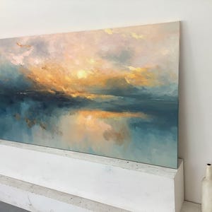 Peut inclure: Une peinture de paysage rectangulaire repr&eacute;sentant une sc&egrave;ne de coucher ou de lever de soleil avec des touches m&eacute;lang&eacute;es de jaune dor&eacute;, d'orange doux et de bleu sarcelle profond. La composition montre une ligne d'horizon au-dessus de l'eau.