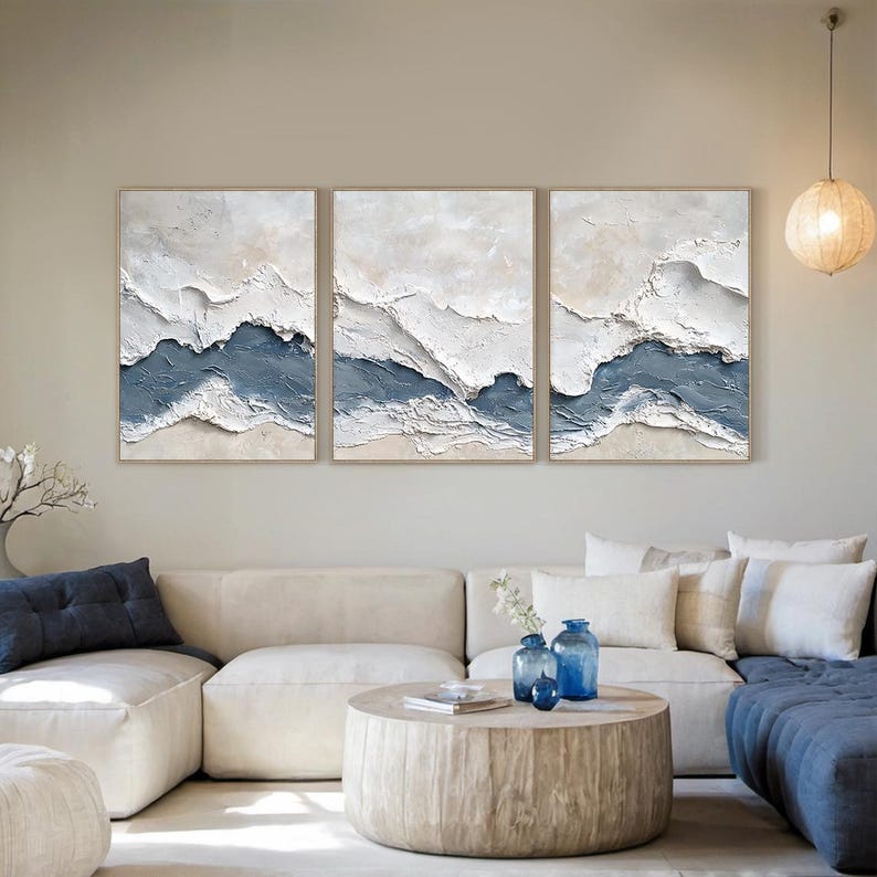 May include: A triptych wall art set featuring three rectangular canvases with heavy impasto texture. The artwork displays abstract horizontal layers of white, cream, and muted blue paint, creating a raised, sculptural effect across all panels.