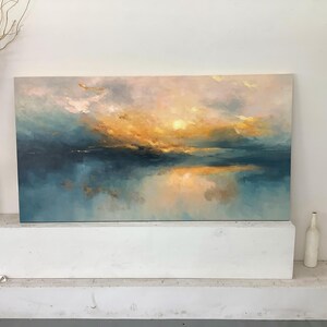 Peut inclure: Une peinture de paysage rectangulaire pr&eacute;sentant un m&eacute;lange de tons bleu sarcelle profond, bleu doux et jaune dor&eacute; chaud. L'&oelig;uvre repr&eacute;sente un horizon atmosph&eacute;rique et brumeux avec une lumi&egrave;re se refl&eacute;tant sur une surface calme.