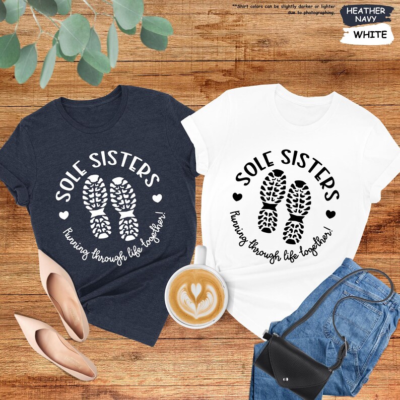 a couple of t - shirts sitting on top of a wooden table