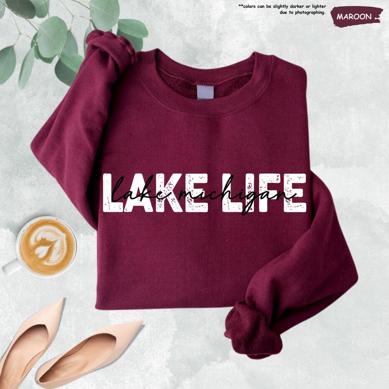 Peut inclure: Un sweat-shirt &agrave; col rond et manches longues de couleur bordeaux avec le texte blanc vieilli "LAKE LIFE" et les mots "lake michigan" &eacute;crits en &eacute;criture cursive noire superpos&eacute;s au centre des lettres blanches.