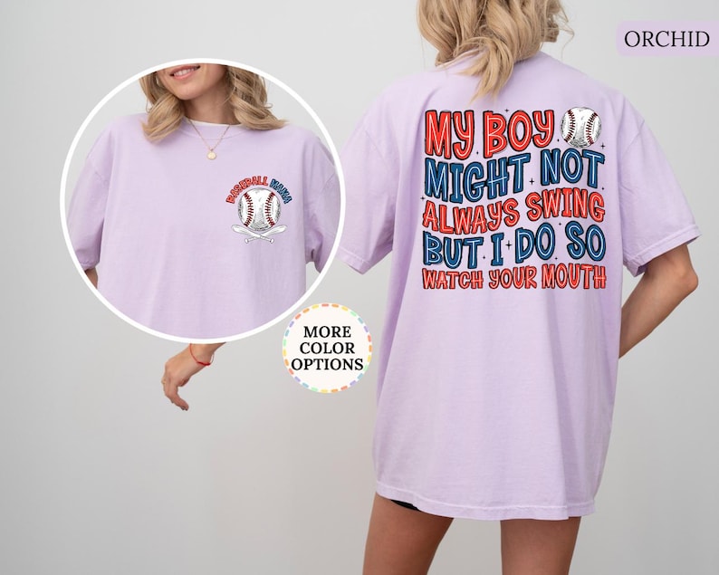 May include: Orchid-colored t-shirt with baseball-themed graphics. The front features a baseball and the words "Baseball Mom." The back displays the text "My boy might not always swing but I do so watch your mouth" in red and blue.