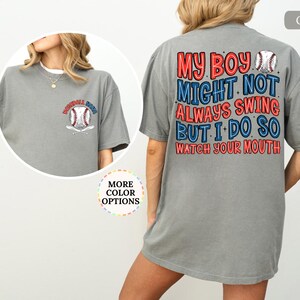 May include: Gray baseball-themed t-shirt with the text "MY BOY MIGHT NOT ALWAYS SWING BUT I DO SO WATCH YOUR MOUTH" on the back. The front features a baseball and crossed bats design with the text "BASEBALL MOM".