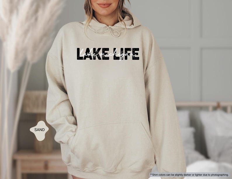 Peut inclure: Un sweat &agrave; capuche couleur sable arborant le texte LAKE LIFE dans une police noire &eacute;paisse et vieillie, avec les mots lake michigan inscrits en fine &eacute;criture cursive blanche au centre de la poitrine et une poche kangourou sur le devant.