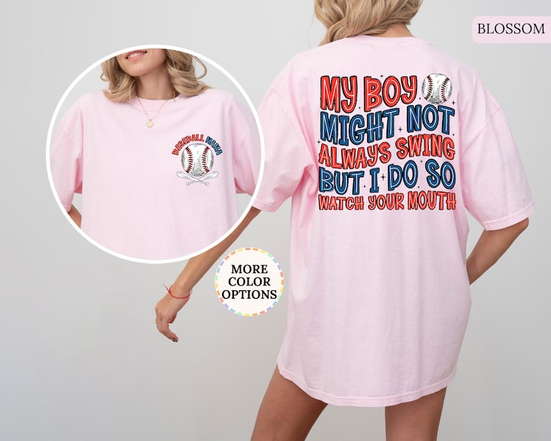 May include: A light pink t-shirt with baseball-themed graphics. The front features a baseball and crossed bats with the text "Baseball Mom". The back displays the text "My Boy Might Not Always Swing But I Do So Watch Your Mouth" with baseball graphics.
