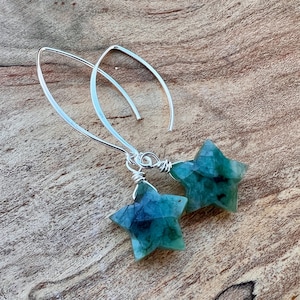 Puede incluir: Un par de pendientes de aro de plata con colgantes de estrella de piedra preciosa verde.