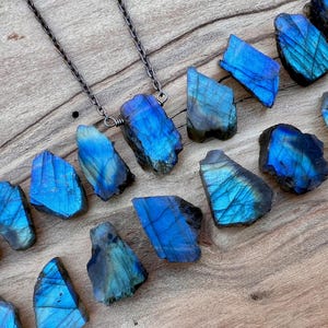 a collection of blue and black gemstones, including various types of stones, arranged on a wooden surface.