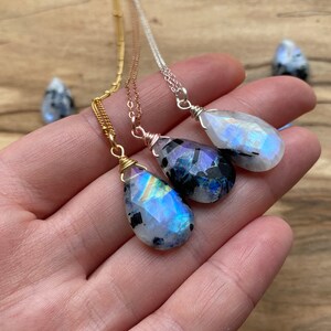 Puede incluir: Tres collares de plata, oro y oro rosa con colgantes de piedra de luna arco&iacute;ris en forma de l&aacute;grima.
