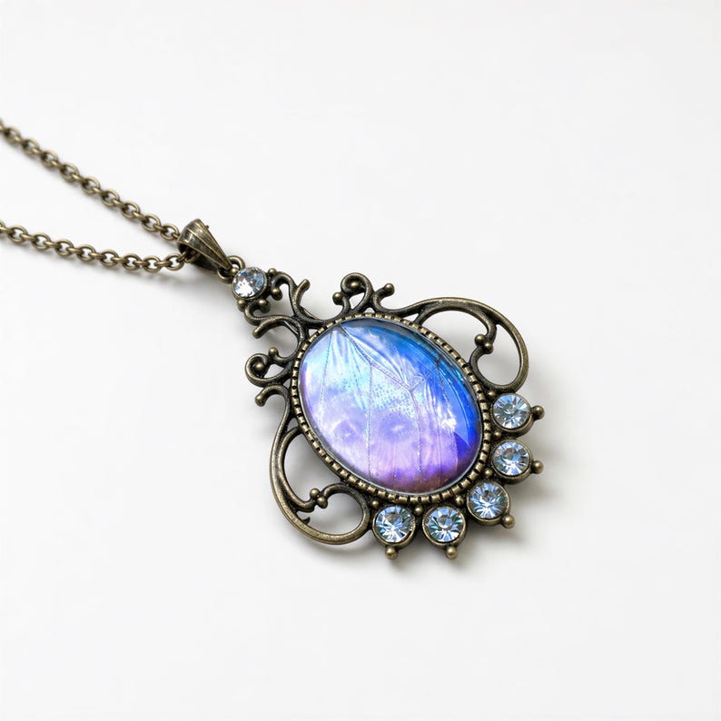 A decorative pendant necklace with a blue and purple stone in the center, surrounded by small blue gemstones.
