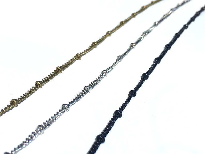 Peut inclure: Trois cha&icirc;nes avec des perles de diff&eacute;rentes couleurs. Les cha&icirc;nes sont argent&eacute;es, noires et dor&eacute;es.