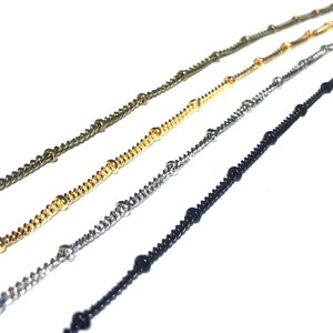 K&ouml;nnte beinhalten: Vier verschiedene Kettenarten mit Perlen, darunter Gold, Silber, Schwarz und Bronze.