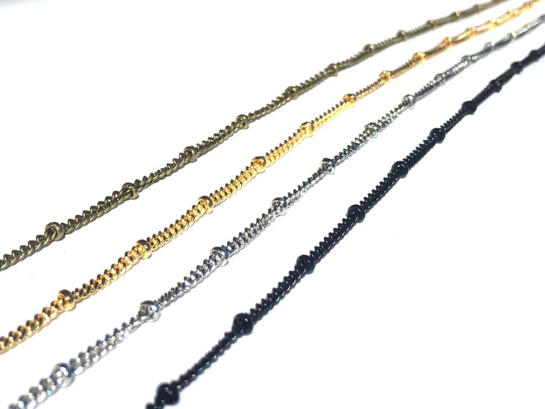 K&ouml;nnte beinhalten: Vier verschiedene Kettenarten mit Perlen, darunter Gold, Silber, Schwarz und Bronze.