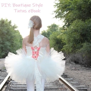 May include: A young girl wearing a white tulle tutu with a pink ribbon and a white lace trim. The tutu is tied with a bow at the back. The girl is standing on a set of railroad tracks. The text "DIY: Boutique Style Tutus eBook" is written in pink at the top of the image.